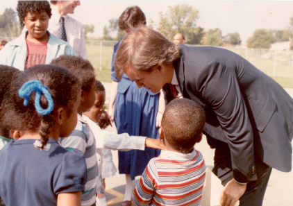 A group of young children gather round as the ribbon is cut.